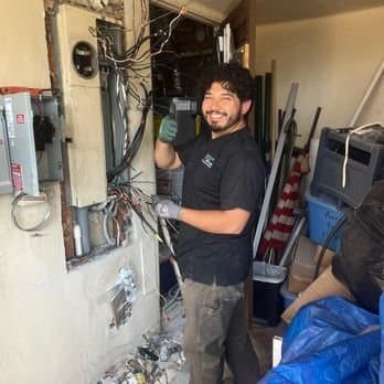 A System Wide Services electrician servicing an electrical panel