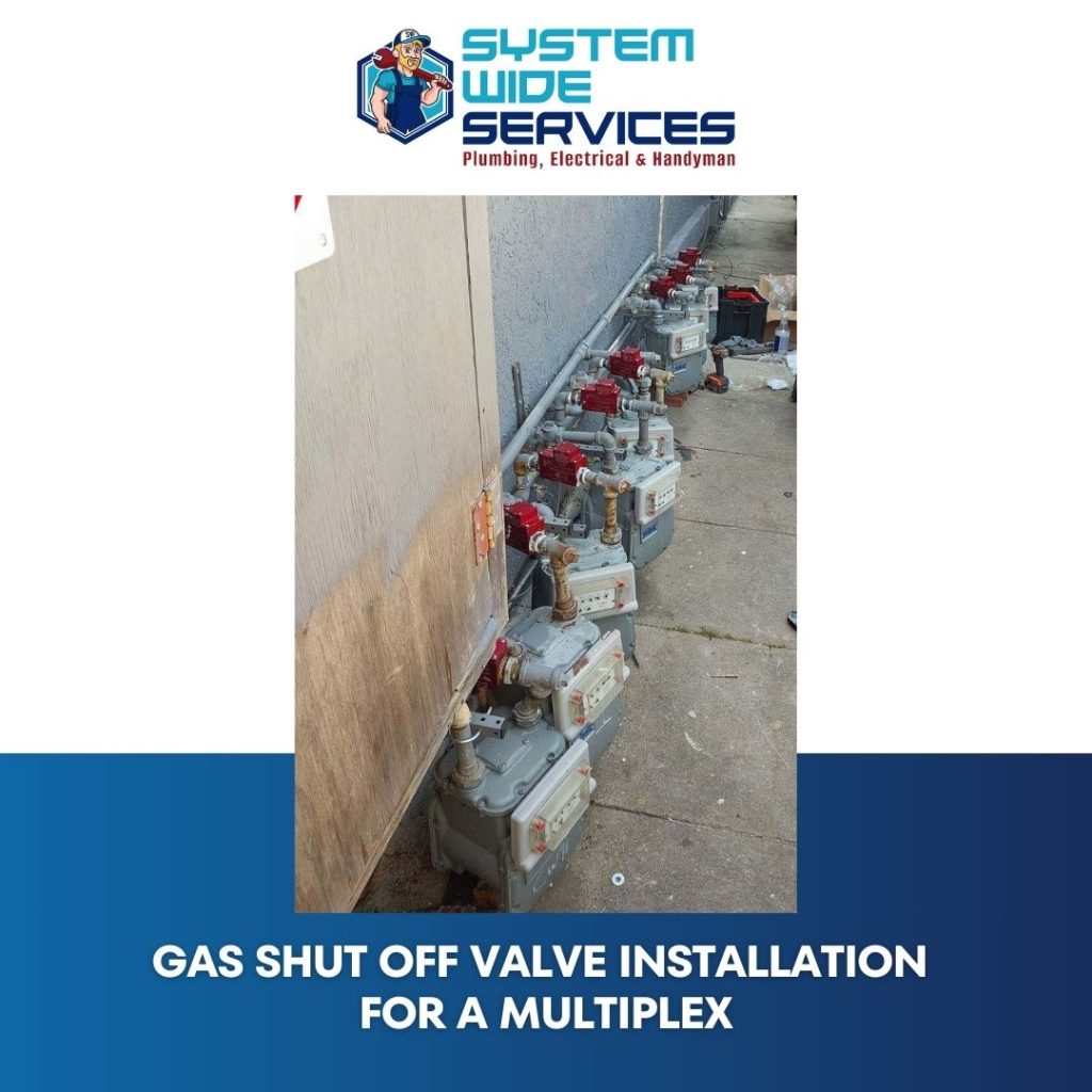 Gas shut-off valve installation for a multiplex by System Wide Services, showcasing multiple valves with red handles along a wall, emphasizing plumbing expertise and service quality.